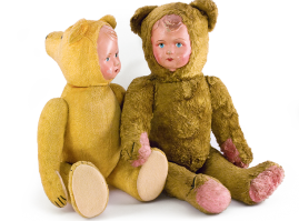 Δύο λούτρινα αμφιπρόσωπα αρκουδάκια, ελληνικά, γύρω στο 1950. Στη μία όψη το πρόσωπο σε μορφή αρκούδας, η άλλη όψη έχει τη μορφή μικρού παιδιού από παπιέ μασέ