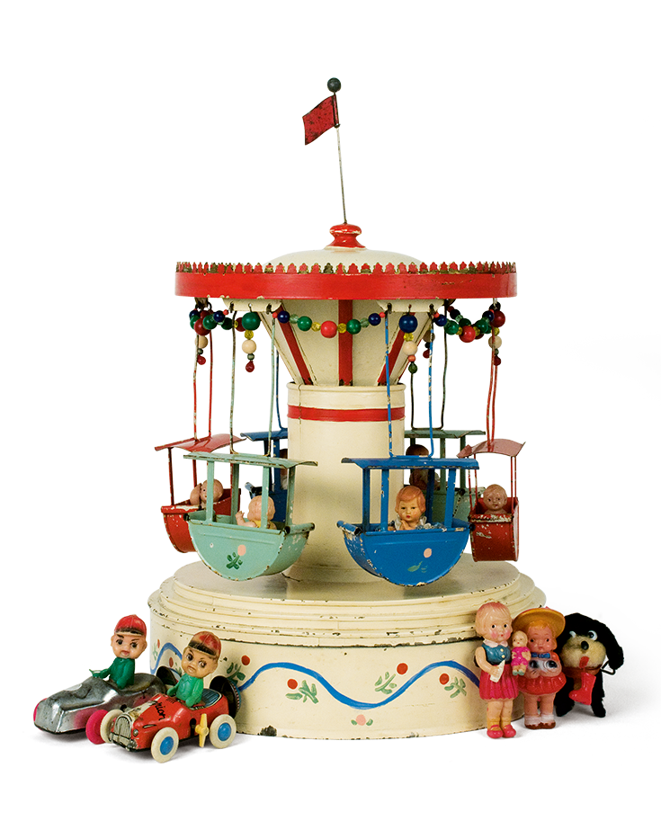 Tin folk-themed carousel from the 1930s-1940s. Small celluloid children are seated in the suspended colourful boats