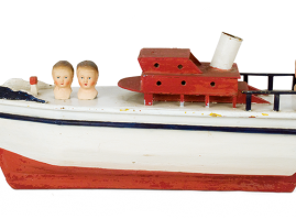Wooden boat with a tin smokestack, handcrafted on Lemnos in the 1950s. The doll heads, of Greek origin, are supplemental and are made of papier-mâché