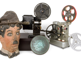 Οικιακές ηλεκτρικές κινηματογραφικές μηχανές αμερικάνικης προέλευσης και κεφάλι του «Σαρλώ» (Τσάρλι Τσάπλιν) από papier mache, ελληνικής προέλευσης, άγνωστου κατασκευαστή