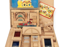 Building toy in a case with wooden pieces in geometrical shapes, depicting embossed and painted architectural elements to make building façades